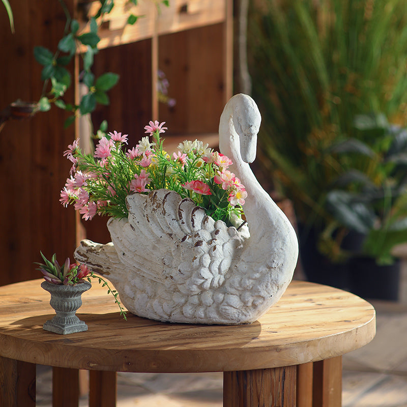 Weathered Swan Garden Planter styled in a lush garden setting