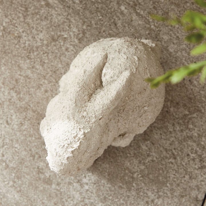 Weathered terracotta bunny garden statue in a soft, aged white finish, perfect for outdoor charm and whimsy.