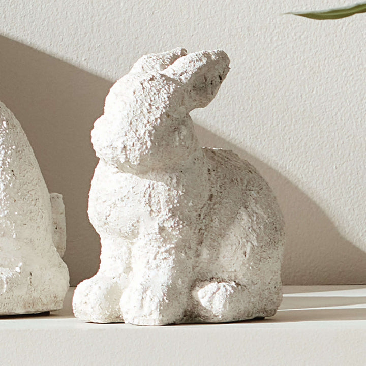 Weathered terracotta bunny garden statue in aged white, perfect for adding rustic charm to outdoor spaces.