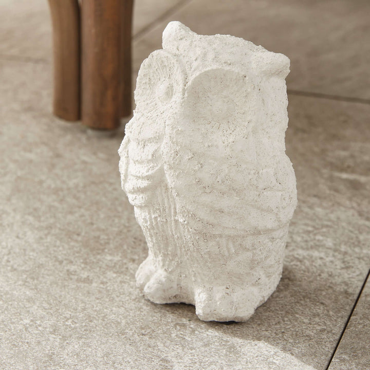 Weathered terracotta owl garden statue in soft whitewash, adding charm to outdoor spaces.