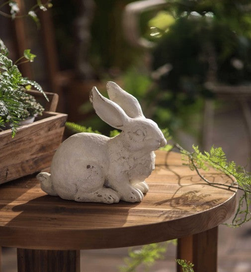 Resting Weathered White Bunny Figurine styled with garden greenery