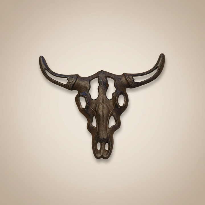 Decorative metal bull skull wall art on a beige background