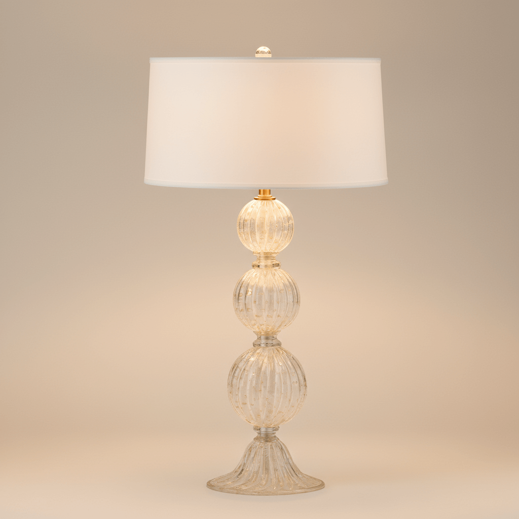 Decorative table lamp with glass base and white shade on a beige background