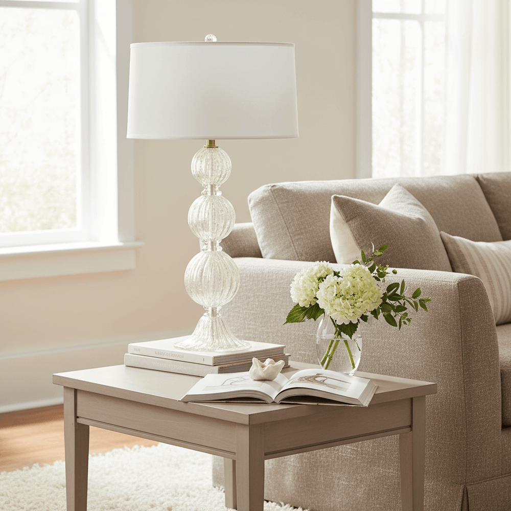 Living room with beige sofa, coffee table, lamp, and flowers