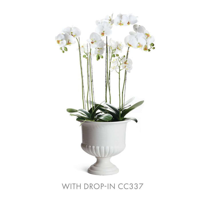 White ceramic urn planter featuring elegant orchids, perfect for Tuscan-inspired home decor.