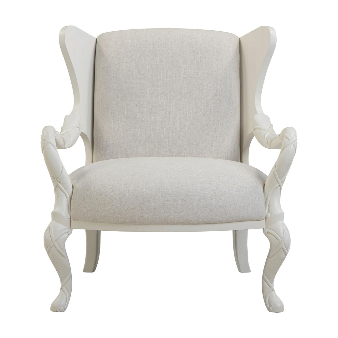 Front view of the ivory upholstered chair showing its winged back and flowing whitewash arms.