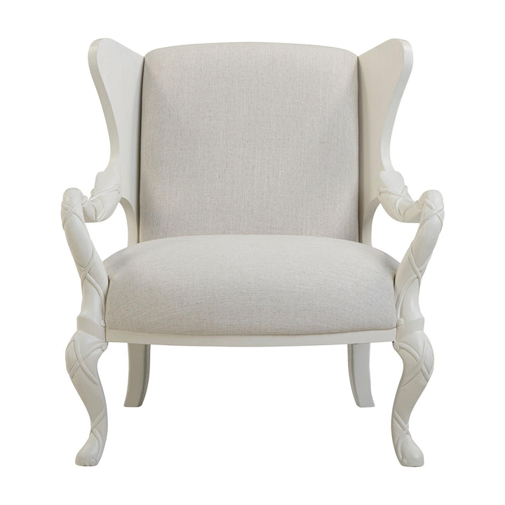 Front view of the ivory upholstered chair showing its winged back and flowing whitewash arms.