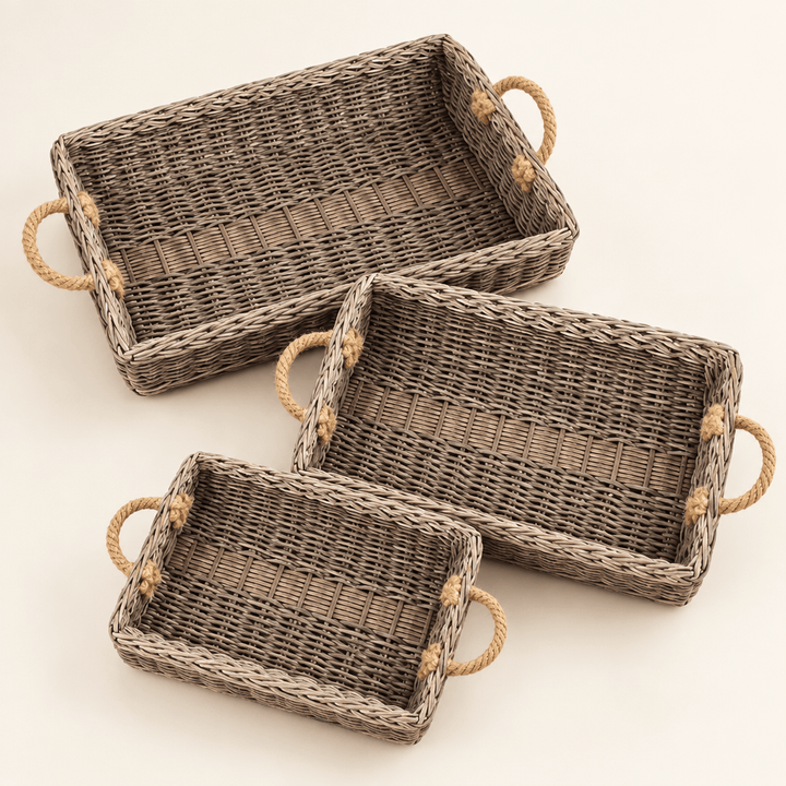 Three graduated rectangular willow trays with jute handles on an ivory background