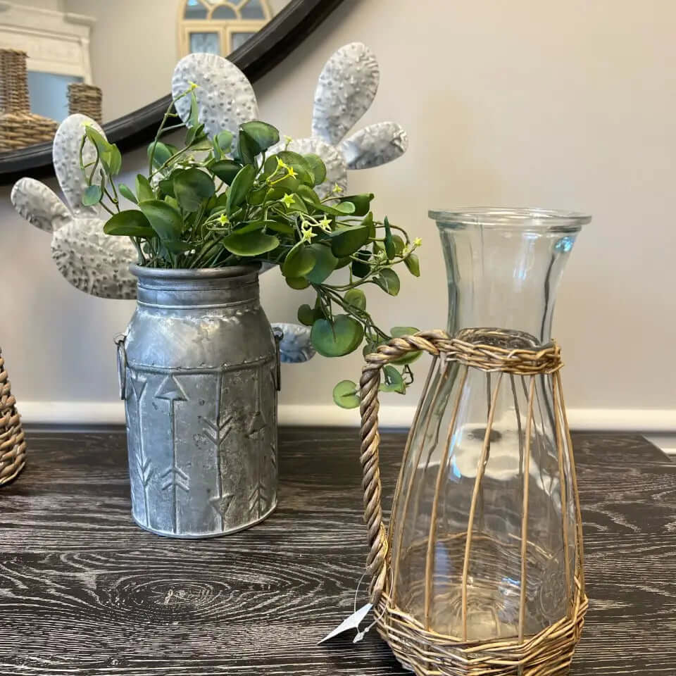 Clear glass pitcher with woven willow jacket in a styled room