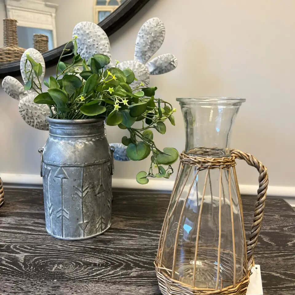 Willow-wrapped glass pitcher standing on a dark wood table
