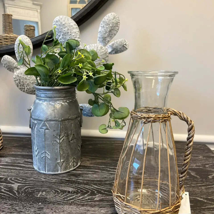 Willow-wrapped glass pitcher standing on a dark wood table