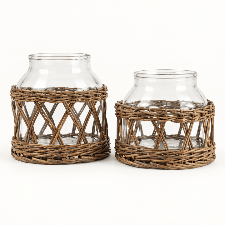 Two clear glass vases wrapped in natural willow lattice, showing the taller and shorter sizes on ivory