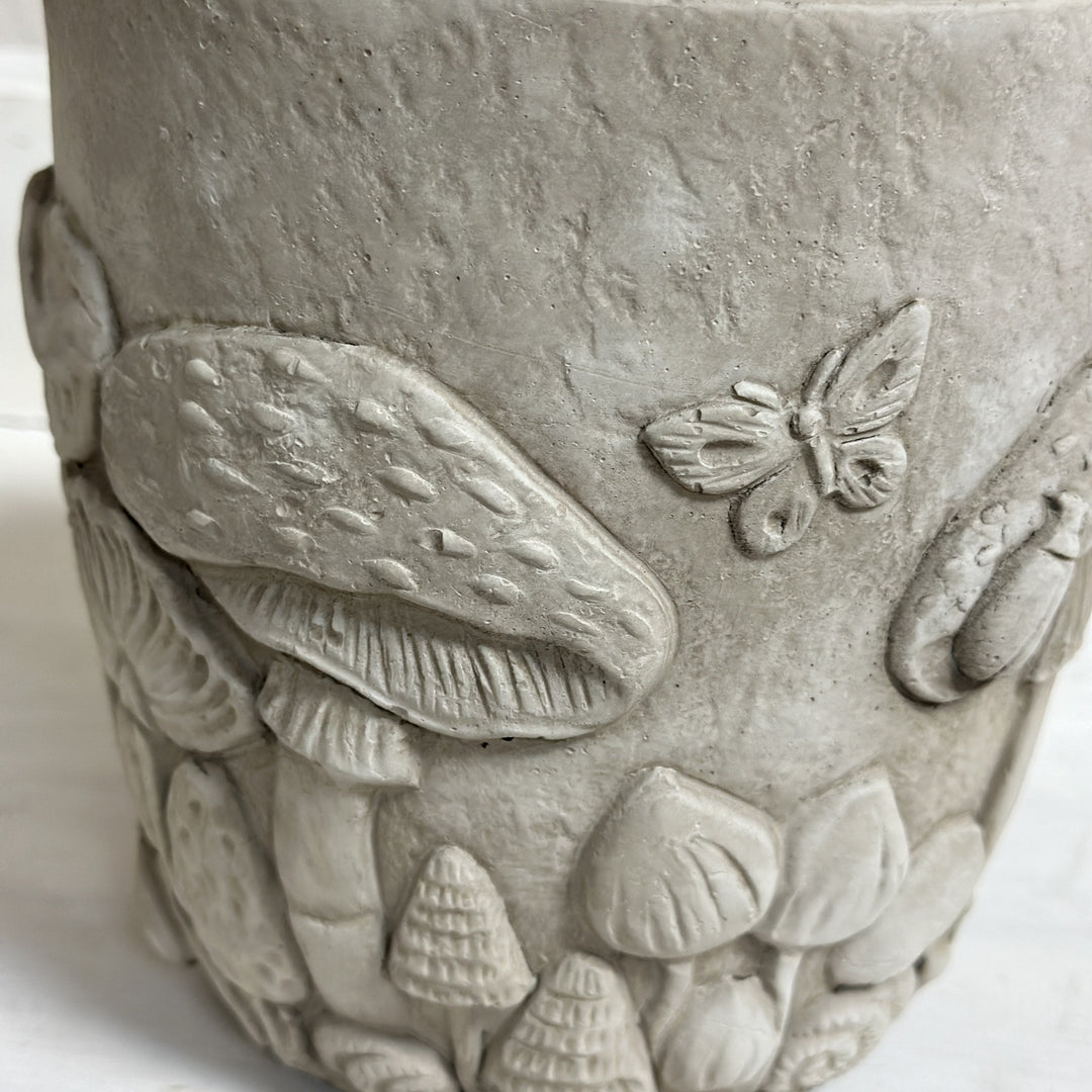 Close-up of the raised mushroom caps, leaves, and butterfly relief