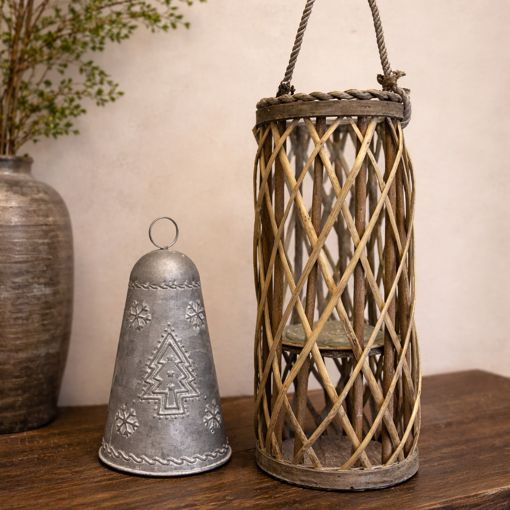 Tall willow lantern with rope handle beside a bell ornament