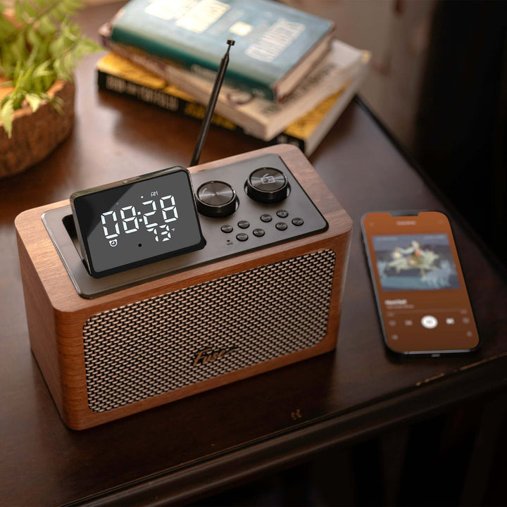 Wooden clock radio with digital display on a table next to a smartphone